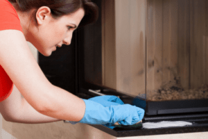 Image of a woman cleaning a gas fireplace